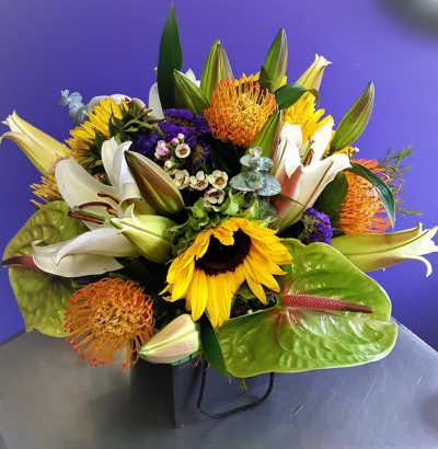 African Savanna - Sunflowers, Anthurium, Lilies, pin cushions, protea and/or Strelitzia when the season allows, using flowers indigenous to the country and those grown locally through different seasons always with a pop of colour - variety of flowers will vary based on season. substitution based on availability