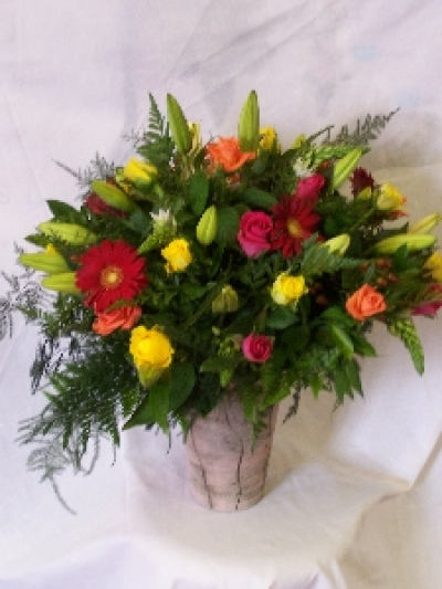 Rainbow - An arrangement of seasonal choice flowers arranged in a beautiful blend of colours and prepared in a container.